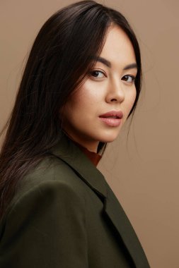 Çekici takım elbiseli, bej arka planda poz veren bir portre kadını. Yüksek kalite fotoğraf