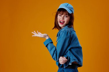 Güzel bayan kot şapkalı kırmızı dudaklar moda sarısı arkaplanı değiştirmez. Yüksek kalite fotoğraf