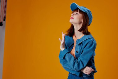 Beautiful fashionable girl denim cap red lips glamor fashion color background unaltered. High quality photo
