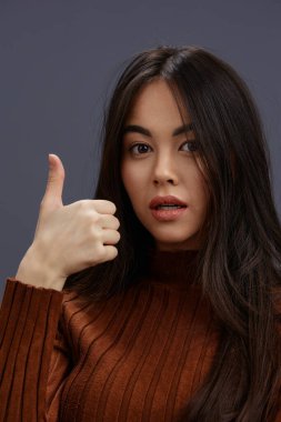 Portre kadın kahverengi süveter cazibeli gülümseme moda gri arka plan. Yüksek kalite fotoğraf