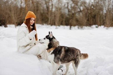 Neşeli kadın kış kıyafetleri karda köpeği gezdiriyor. Yaşam tarzı. Yüksek kalite fotoğraf