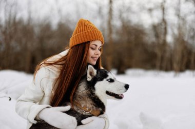 Karda bir kadının portresi köpek arkadaşlığı kış tatilinde eğlencesine oynuyor. Yüksek kalite fotoğraf