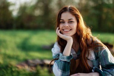 Yeşil bir parkta gülen ve gülümseyen bir kadın. Yüksek kalite fotoğraf
