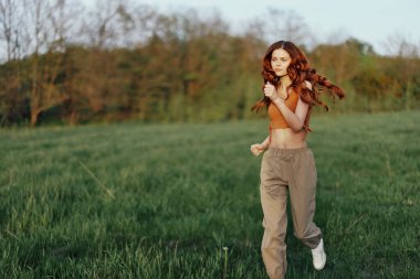 Bir kadın odaklanmış bir yüzle koşuyor, açık hava aktivitesinden sonra yorgun. Yüksek kalite fotoğraf