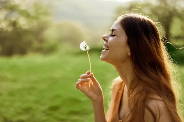 女性は微笑み タンポポの種子を風に吹きます 夏と日没のライト 高品質の写真 — ストック写真