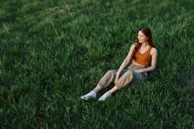 Parkta yeşil çimlerde oturan bir kadın, yukarıdan manzaralı. Yüksek kalite fotoğraf