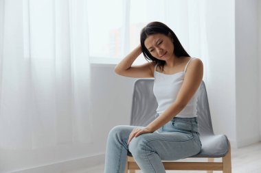 Baş dönmesi travması. Izdırap çeken, bronzlaşmış, güzel, Asyalı bir kadın. Başı dokunuyor. Evde, oturma odasında baş ağrısı hissediyor. Yaralar Kötü Sağlık Hastalığı konsepti. Güzel teklif Banner.