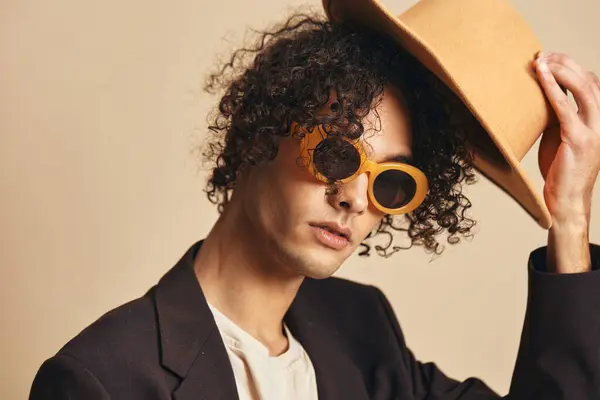 穿着棕色夹克的时髦太阳镜 头戴一顶经典的帽子 背景是米黄色 背景是米黄色的 时尚新系列提供 复古风格的概念 免费的广告位 — 图库照片