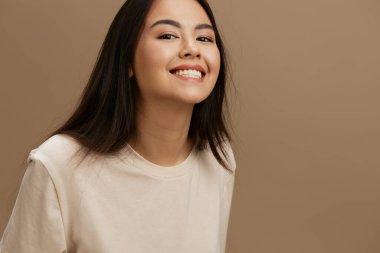 Bej tişörtlü güzel bir kadın moda stüdyosu modeli pozu veriyor. Yüksek kalite fotoğraf