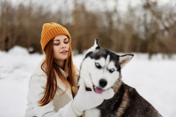 在雪地里快乐的女人在外面和狗玩耍友谊生活方式 高质量的照片 — 图库照片