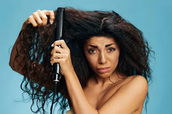 Attraktive Verwirrt Lockige Latina Mit Einem Haarglätter Posiert Isoliert Auf — Stockfoto