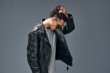 Gri stüdyo arka planında izole edilmiş şık, bronzlaşmış, deri ceketli, moda güneş gözlükleri. Güzel moda teklifi. Büyük Mevsimlik Satış Yeni Koleksiyon konsepti. İlan için alanı kopyala