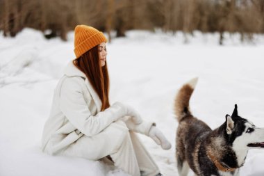 Kadın kış kıyafetleri karda köpeği dolaştırıyor. Temiz hava. Yüksek kalite fotoğraf