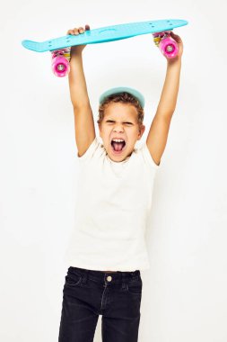 Çocukluğunda elinde poz veren gülümseyen kaykaycı çocuk portresi. Yüksek kalite fotoğraf