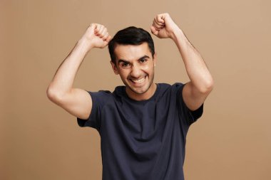 Yakışıklı bir adam gülümseyerek bej rengi kıyafetler giyer. Yüksek kalite fotoğraf