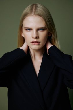 Siyah ceketli güzel bir kızın portresi stüdyodaki yeşil bir arka planda duruyor. Markalar için güzel pankart. Tasarım için harika bir teklif. Yüksek kalite fotoğraf