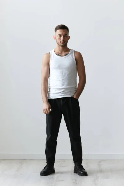 Full body shot of handsome tanned sporty attractive serious man guy posing on white studio background. Fashion Style New Collection Offer. Copy space for ad. Modeling snapshots