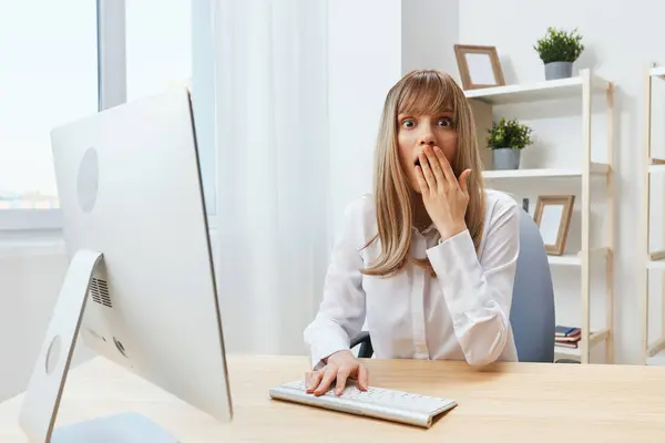 在现代办公室里 兴奋的金发女商人用手捂着嘴思考着问题的解决方案 员工在网上电脑上的工作犯了一个错误或做出了决定 复制空间 — 图库照片