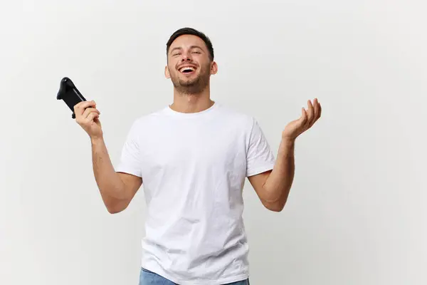 基本的なTシャツのハンサムな男は ホワイトスタジオの背景の上に隔離されたポーズアップジョイスティックゲームパッドで手を笑います スペースバナーモックアップをコピーします ゲーマーRpgコンセプト — ストック写真