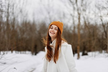 Kış ormanlarında komik bir kış manzarasında, kışlık kıyafetlerle gezen bir kadının portresi. Yüksek kalite fotoğraf