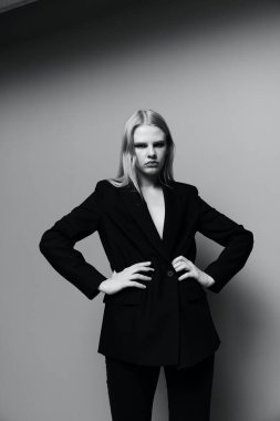 Klasik takım elbiseli profesyonel bir modelin bacaklarıyla orta portre iki elini beline koyup kameraya bakar. Yüksek kalite fotoğraf