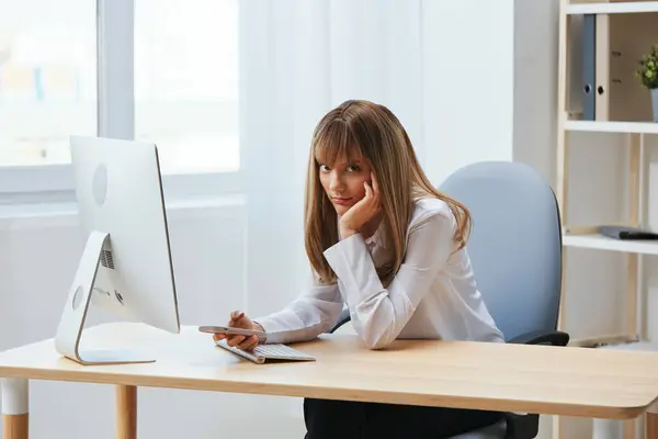 Unhappy sad blonde businesswoman worker freelancer look at camera hold phone typing message in light modern office. Employee work doing breakup chatting with business partner read news. Copy space