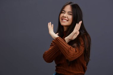 Güzel kadın kahverengi süveter, büyüleyici gülümseme, gri arka plan. Yüksek kalite fotoğraf