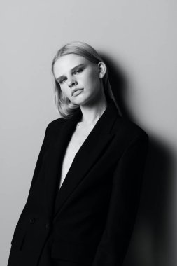 Stüdyoda duvara yaslanmış poz veren güzel bir kız. Yüksek kalite fotoğraf