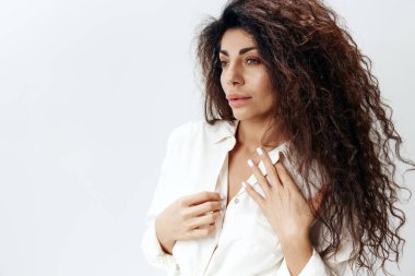FASHION Önerisi. Beyaz Gömlekli Uzun Afro Saçlı Dalgın Latin Kadın Dokunma Yakalı Kadın Beyaz Stüdyo Arkaplan 'da tecrit edilmiş. Banner Mockup kopyalama alanı boş