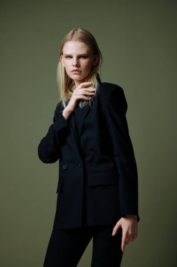 Stüdyoda yeşil arka planda poz veren kendine güveni tam bir genç kadın. Yüksek kalite fotoğraf