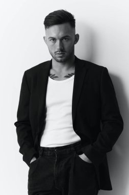 Fotoğrafları modelliyorum. Klasik takım elbiseli, kendine güveni tam yakışıklı bir adam beyaz stüdyo arka planında yalnız poz veren bir adamın elini tutuyor. Siyah ve Beyaz konsepti. Moda teklifi. Boşluğu kopyala