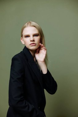 Markalar için güzel pankart. Çekici, havalı profesyonel bir model yarım dönüşle poz veriyor ve stüdyoda yeşil zeytinli arka plandaki kameraya bakıyor. Yüksek kalite fotoğraf