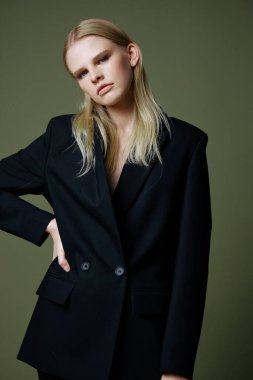 Stüdyoda yeşil arka planda poz veren kendine güveni tam bir genç kadın. Yüksek kalite fotoğraf