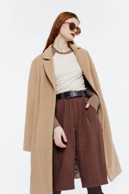 Stüdyoda beyaz bir arkaplanda gözlüklü bir kızın hareket halindeki katalog fotoğrafı. Yüksek kalite fotoğraf