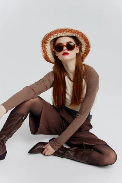 Серьёзная Молодая Модель Шляпе Очках Сапогах Сидит Полу Белой Студии — стоковое фото