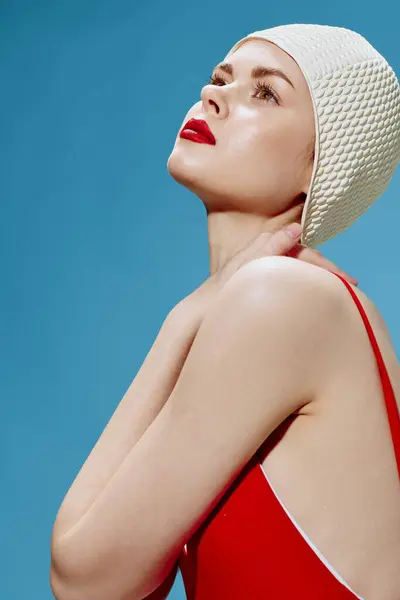 一个戴着复古红色泳帽的可爱女人在蓝色的背景上摆姿势 高质量的照片 — 图库照片