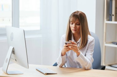 Yakışıklı, sarışın, serbest çalışan bir iş kadını hafif modern ofisteki telefon daktilo mesajlarına bakar. İş ortağıyla ayrılık sohbeti yapan çalışanlar haberleri okuyor. Boşluğu kopyala