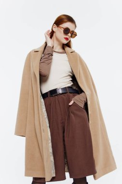 Stüdyoda beyaz bir arkaplanda gözlüklü bir kızın hareket halindeki katalog fotoğrafı. Yüksek kalite fotoğraf