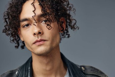 Gri stüdyo arka planında izole edilmiş şık, bronzlaşmış deri ceketli adam portresi. Güzel moda teklifi. Büyük Mevsimlik Satış Yeni Koleksiyon konsepti. İlan için alanı kopyala