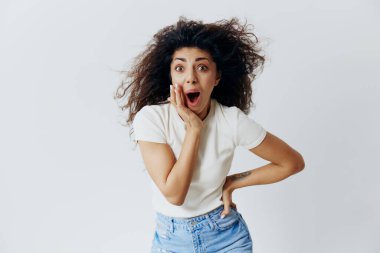 Devasa bir satış teklifi var. Şok olmuş afro saçlı, el ele tutuşmuş, heyecanlı Latin kadın kameraya bakıyor, beyaz arka planda yalnız kalıyor. Boşluğu kopyala, boş yer, moda afişi