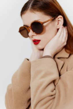 Stüdyoda beyaz bir arka planda gözlüklü genç bir bayanın portresi. Sergi salonu reklamları, tasarımcı kıyafetleri. Yüksek kalite fotoğraf