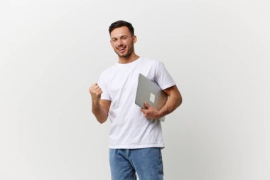 Şanslı, bronz tenli, basit tişörtlü yakışıklı öğrenci yumruğunu kaldır ve beyaz stüdyo arka planında yalnız poz ver. Uzayın afiş modelini kopyala. Elektronik tamir konsepti