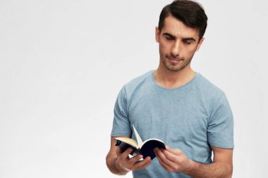 Portreci adam bir defter tişörtü, gözlük, yaşam tarzı ışık arka planına yazıyor. Yüksek kalite fotoğraf