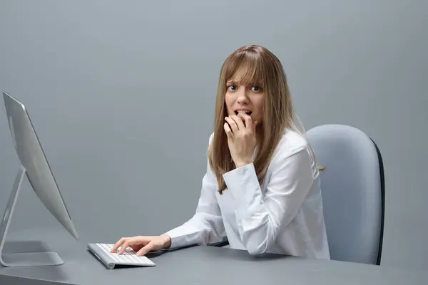 Nervous pretty blonde businesswoman worker freelancer have operation crash using desktop computer sitting at workplace in gray modern office. Remote Job, Technology And Career Profession Concept