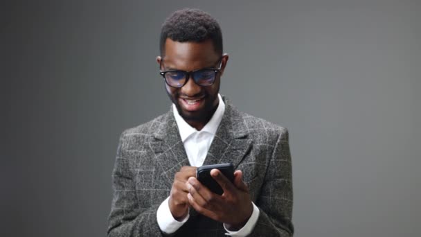 Αφροαμερικάνος Επιχειρηματίας Που Κρατάει Ένα Τηλέφωνο Κοιτάζοντας Και Χαμογελώντας Ενώ — Αρχείο Βίντεο