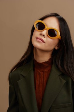 Siyah gözlüklü şık takım elbiseli genç bir kadın izole bir arka plan oluşturuyor. Yüksek kalite fotoğraf