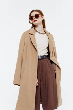 Stüdyoda beyaz bir arkaplanda gözlüklü bir kızın hareket halindeki katalog fotoğrafı. Yüksek kalite fotoğraf