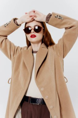 Kızıl saçlı profesyonel bir model, bir giyim markası dergisi için ceket ve gözlüklü poz veriyor. Yüksek kalite fotoğraf