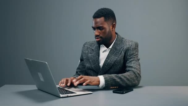 아프리카계 미국인 사업가가 책상에 사무실에 앉아서 노트북을 비즈니스복을 미소를 지으며 — 비디오