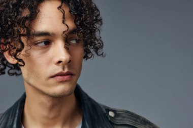 Gri stüdyo arka planında izole edilmiş, bronzlaşmış kıvırcık deri ceketin portresi. Güzel moda teklifi. Büyük Mevsimlik Satış Yeni Koleksiyon konsepti. İlan için alanı kopyala